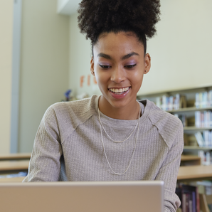 teenager using a laptop in a library